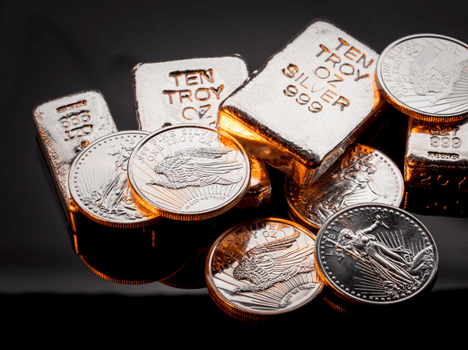 Stacks of silver coins and several silver bars, each marked “TEN TROY OZ SILVER 999,” are displayed on a reflective black surface. The coins feature detailed designs, including an eagle.