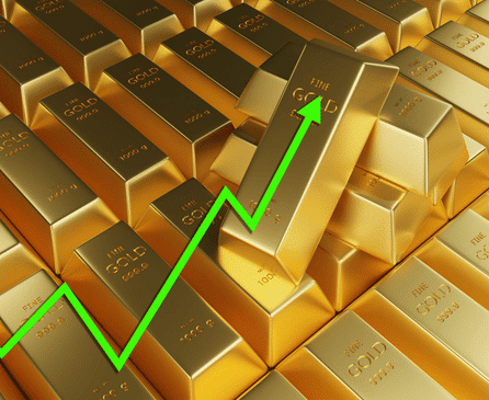 Several gold bars are stacked together, with a bright green upward arrow overlaid, symbolizing an increase in gold value or prices.